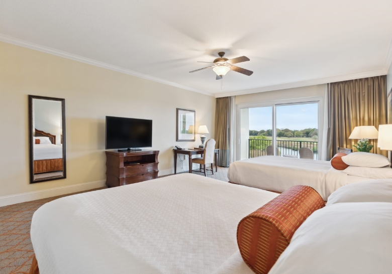 Hotel room featuring two beds and a television, ideal for families visiting Myrtle Beach. Spacious and comfortable accommodations.