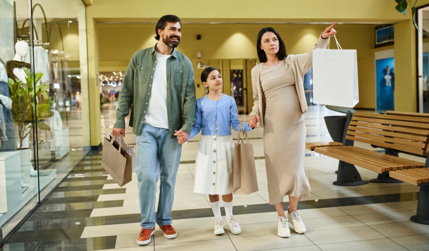 A family strolls through Barefoot Landing mall in Myrtle Beach, carrying shopping bags and enjoying their day together.