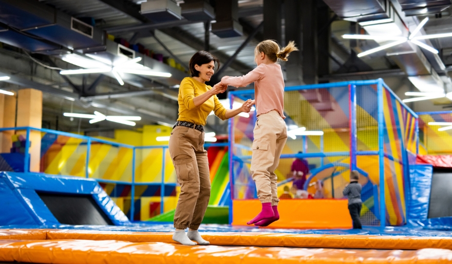 Two women joyfully jumping on an inflatable trampoline at Big Air Trampoline Park in Myrtle Beach, designed for kids' fun.