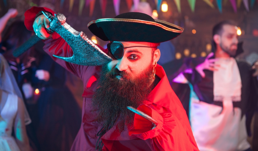 A man dressed as a pirate with a beard brandishes a knife, representing Myrtle Beach's Pirates Voyage Dinner & Show.
