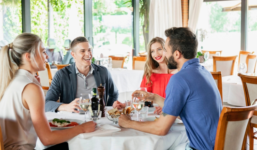 A group of friends enjoying dinner together at a restaurant in Myrtle Beach's Broadway at the Beach.