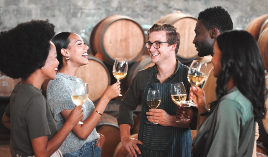A group of individuals is in a wine cellar, participating in a winery tour as part of Myrtle Beach group activities.