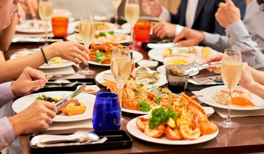 A group of friends enjoying a meal together at a table, surrounded by various dishes, during a Myrtle Beach getaway.