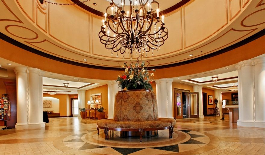 Hotel lobby featuring an elegant chandelier and a large table, welcoming guests for check-in at Marina Inn at Grande Dunes.