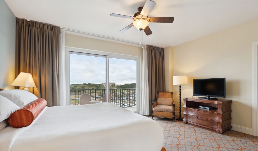 Spacious bedroom with a king-size bed and flat-screen TV, designed for a relaxing Myrtle Beach getaway at Marina Inn.