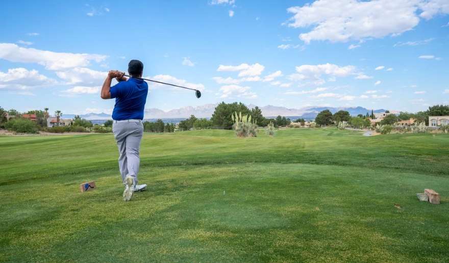 A man swings a golf club on the green at Grande Dunes Resort Course during a Myrtle Beach weekend getaway.
