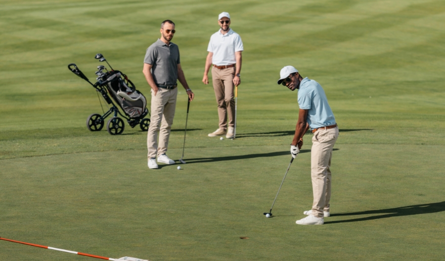 Three men playing golf on a green course at Myrtle Beach golf course.