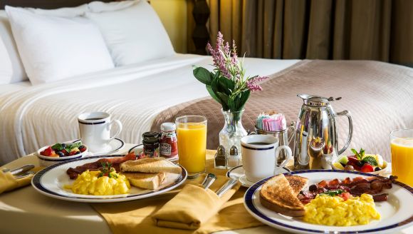 A cozy breakfast scene in a Myrtle Beach hotel room, with an assortment of gourmet foods and beverages for guests to enjoy.