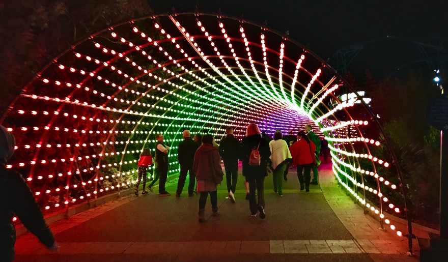 People stroll through a brightly lit tunnel at Myrtle Beach's Great Christmas Light Show in November.