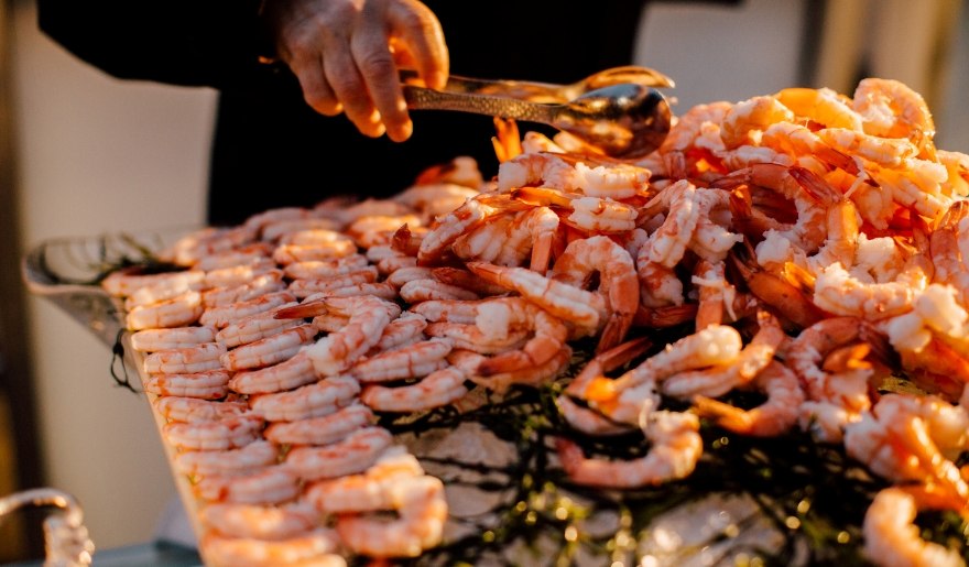 At Myrtle Beach's Little River ShrimpFest, a man proudly displays a large tray filled with fresh shrimp for festival attendees.