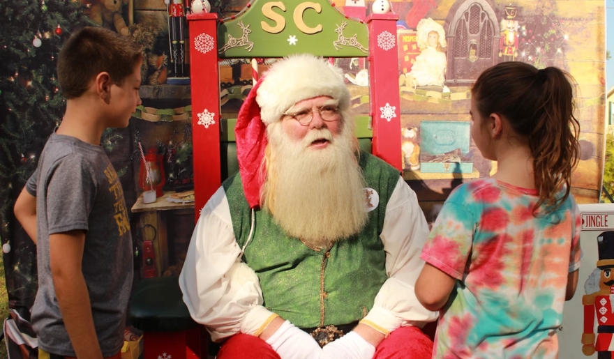 Santa Claus greets visitors at the fairgrounds for holiday photos during the Myrtle Beach Christmas celebration at Tanger Outlets.