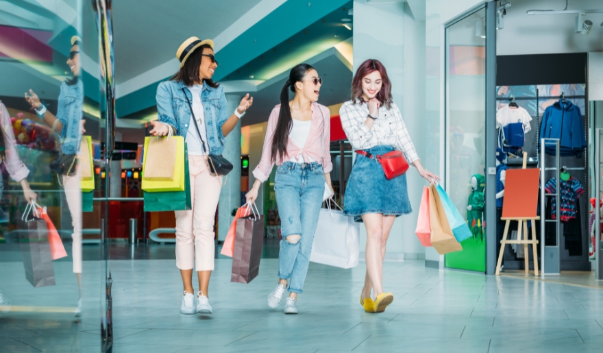 Three women with shopping bags walk through a mall, enjoying Myrtle Beach's Black Friday and Small Business Saturday.