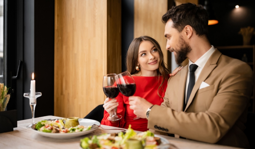 Romantic dinner scene of a couple with wine at a Myrtle Beach restaurant, highlighting Valentine's Day offerings.