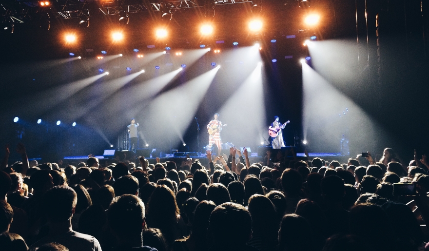 A vibrant crowd enjoying an indoor concert in Myrtle Beach, illuminated by bright stage lights in January.
