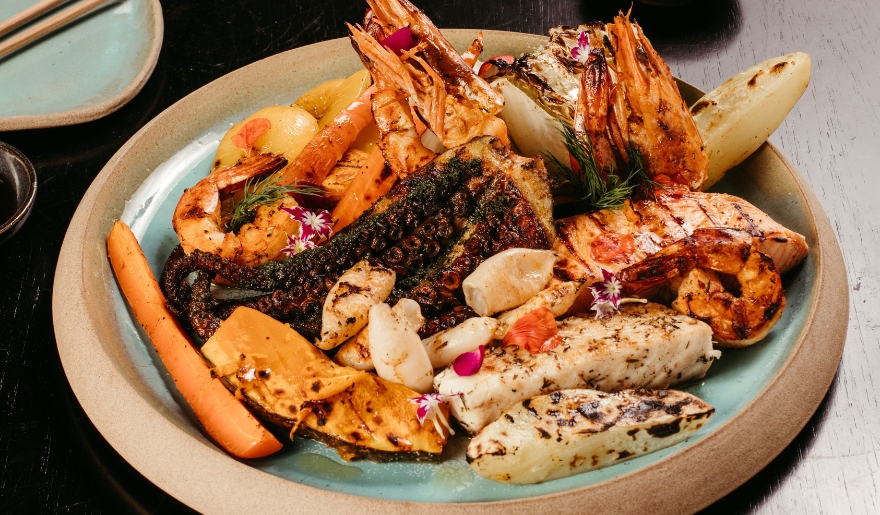 A gourmet plate with shrimp, fish, and vegetables, highlighting Myrtle Beach's Restaurant Week in January.