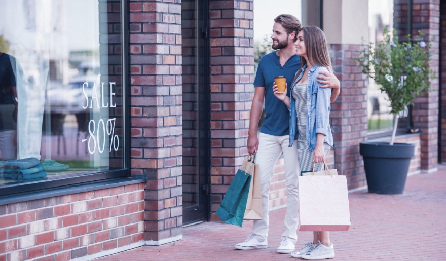 A man and woman stand outside a store at The Market Common in Myrtle Beach, holding shopping bags in January.