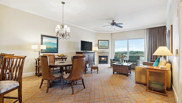 A spacious resort living and dining area with a balcony view