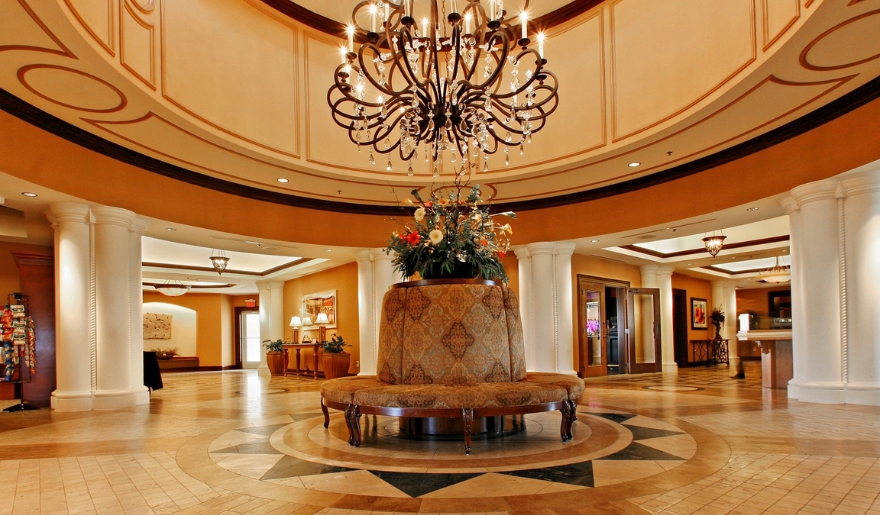 Luxurious hotel lobby with a chandelier and round table, highlighting exclusive March specials in Myrtle Beach.