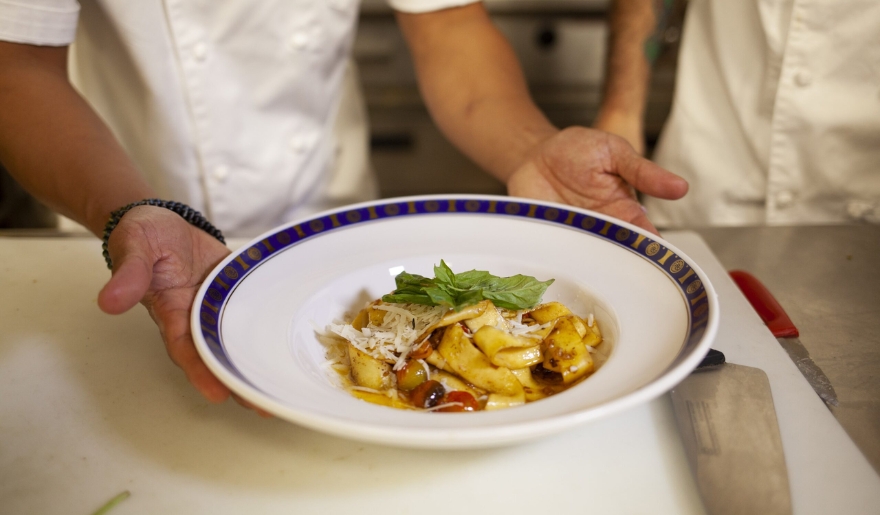 Two chefs hold a bowl of food on a counter during an on-site dining experience in Myrtle Beach, March.