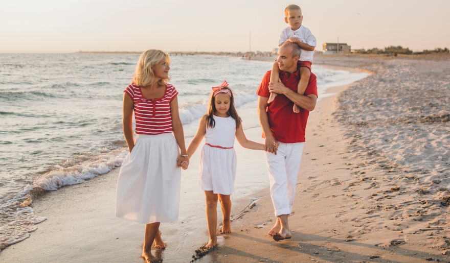A family enjoys a sunset walk on the beach, capturing the essence of togetherness and the beauty of Myrtle Beach.