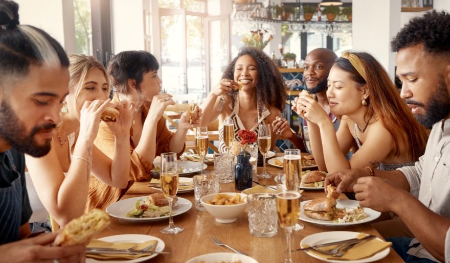 A group of diverse people enjoying a meal together at a casual restaurant in Myrtle Beach, highlighting family-friendly dining.