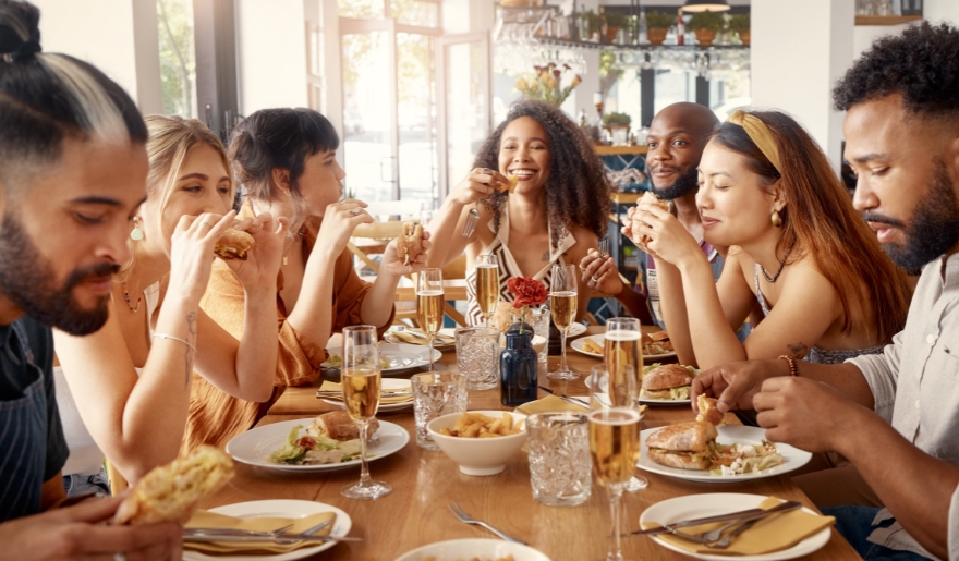 A group of diverse people enjoying a meal together at a casual restaurant in Myrtle Beach, highlighting family-friendly dining.