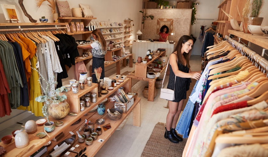 A woman looking at apparel in a clothing store, representing shopping tips for Myrtle Beach travelers.