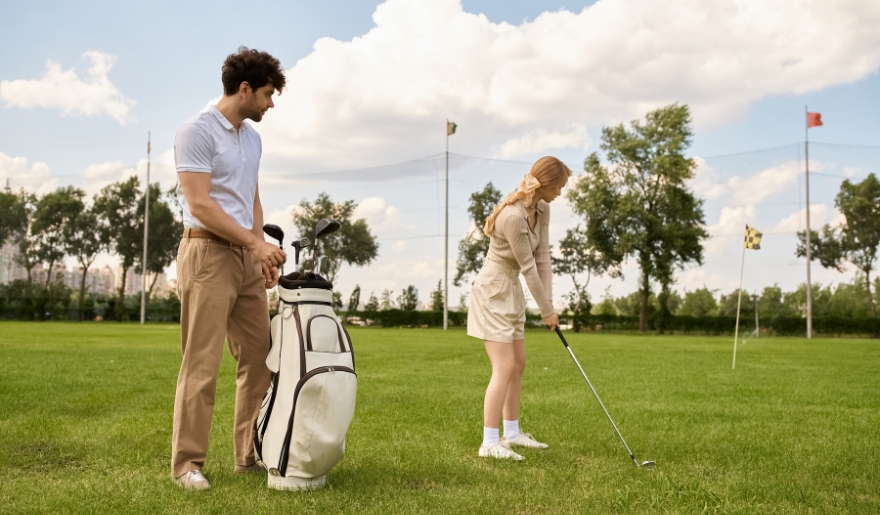 A man and woman are engaged in a game of golf on a scenic green field, representing Myrtle Beach's golfing attractions.