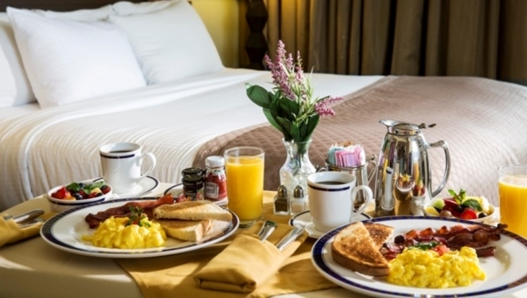 In-room breakfast service at Myrtle Beach hotel with fresh meal setup on bed for guests