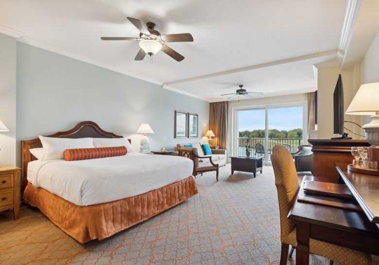 Spacious luxury suite at Myrtle Beach resort with king bed, seating area, and balcony view