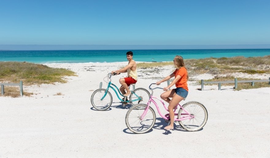 Couple riding bikes toward the beach, planning a scenic route along Myrtle Beach bike trails