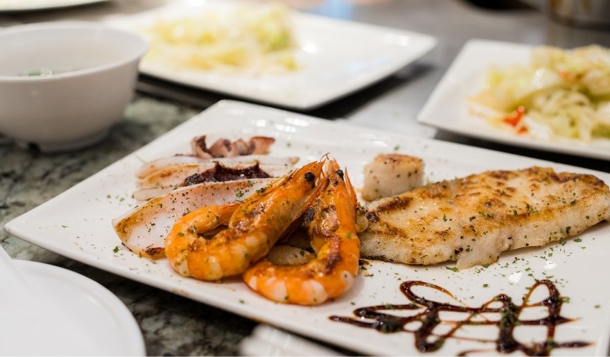 Grilled seafood plate with shrimp, fish, and scallops served with sauce