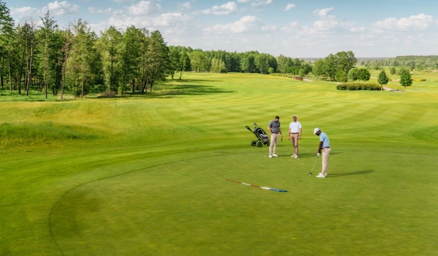 Group of golfers on a manicured green at Grande Dunes Resort Golf Club, highlighting championship golf access near Marina Inn at Grande Dunes in Myrtle Beach.