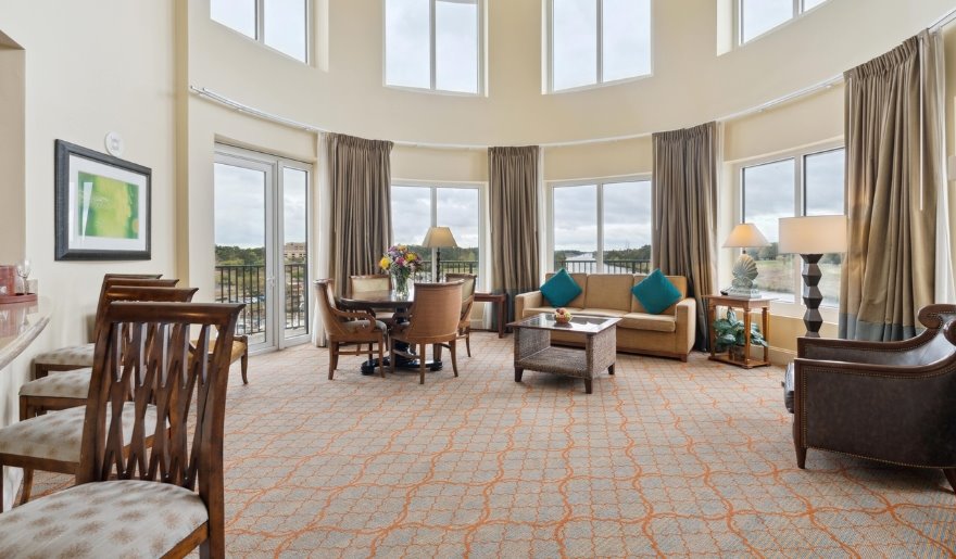 Large suite interior at Marina Inn at Grande Dunes featuring dining table, seating area, and expansive windows, highlighting accommodations with space for in-suite meals and extended stays in Myrtle Beach.