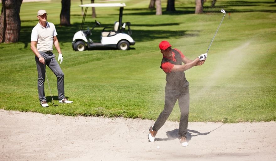 Golfers playing on a Myrtle Beach championship course with sand bunker and scenic fairway views