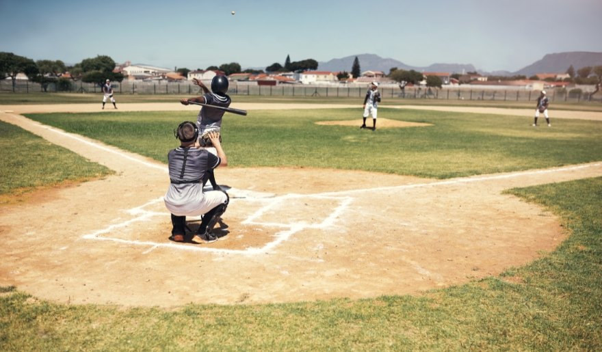 A baseball player stands on the field, holding a ball, during a Myrtle Beach Pelicans game for kids.
