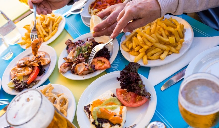 A person enjoying a meal at a table filled with various dishes, highlighting family-friendly dining in Myrtle Beach.