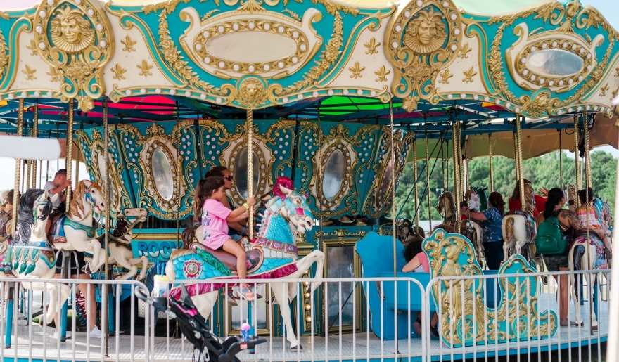 Children joyfully ride a colorful carousel at Family Kingdom Amusement Park during a Myrtle Beach family vacation.