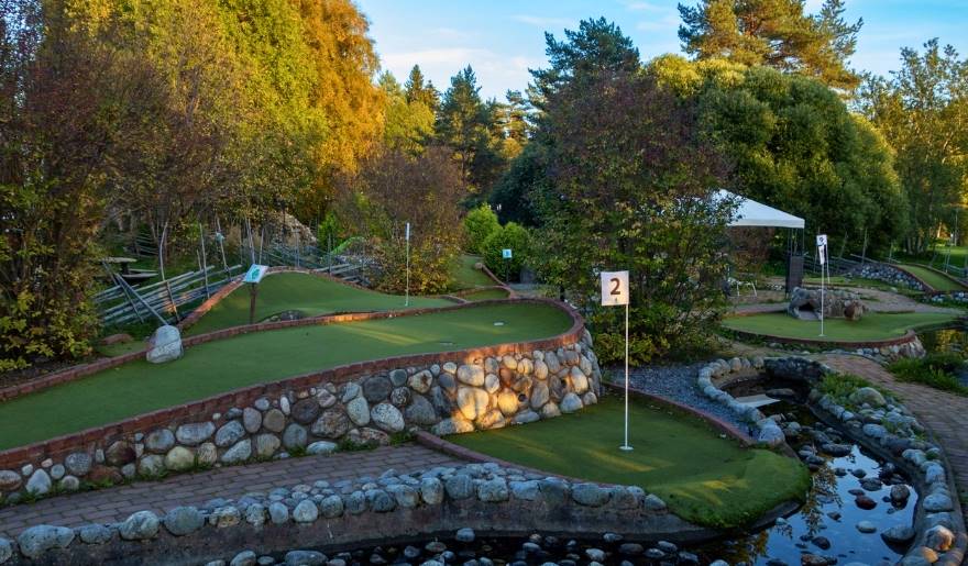 Scenic miniature golf course with a pond and trees, perfect for family fun during a Myrtle Beach vacation.