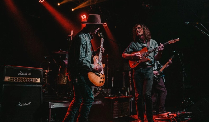 Two musicians playing guitars on stage during a concert at Tin Roof Myrtle Beach, highlighting the lively atmosphere.