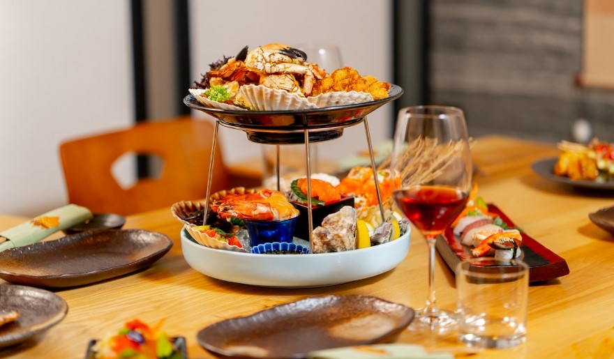 A table set with various dishes and wine glasses, showcasing a dining experience at 21 Main at North Beach, Myrtle Beach.