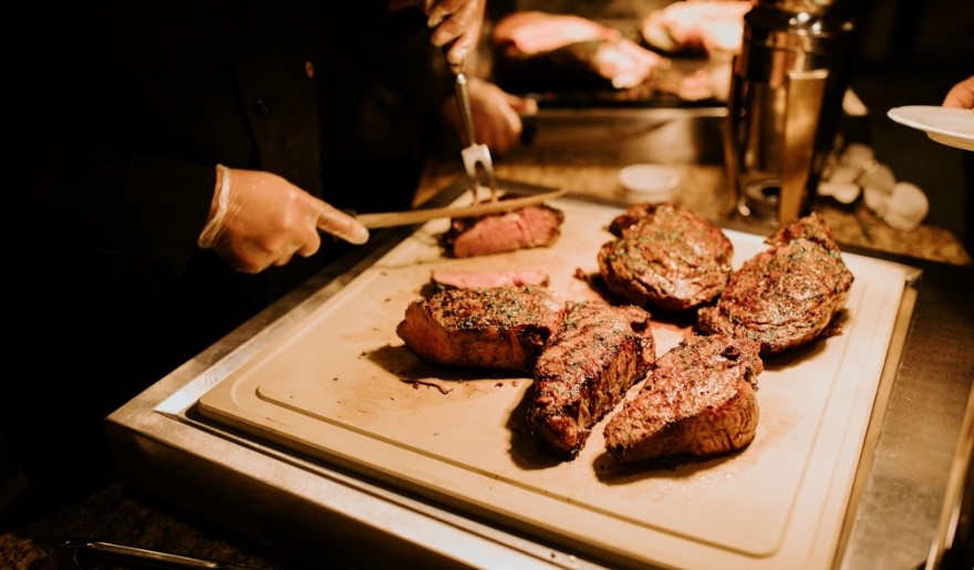 A man slices meat on a cutting board at Aspen Grille, a restaurant in Myrtle Beach for large groups.