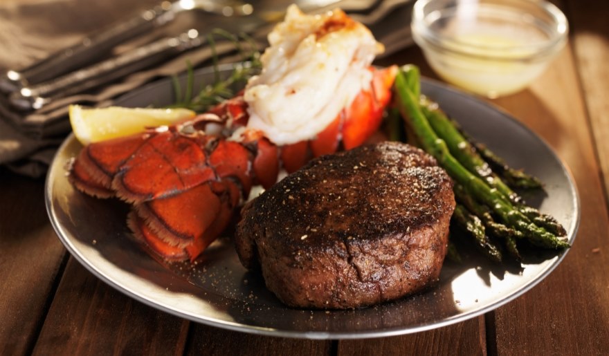 A gourmet plate featuring steak, lobster, and asparagus, served at Greg Norman Australian Grille in Myrtle Beach.