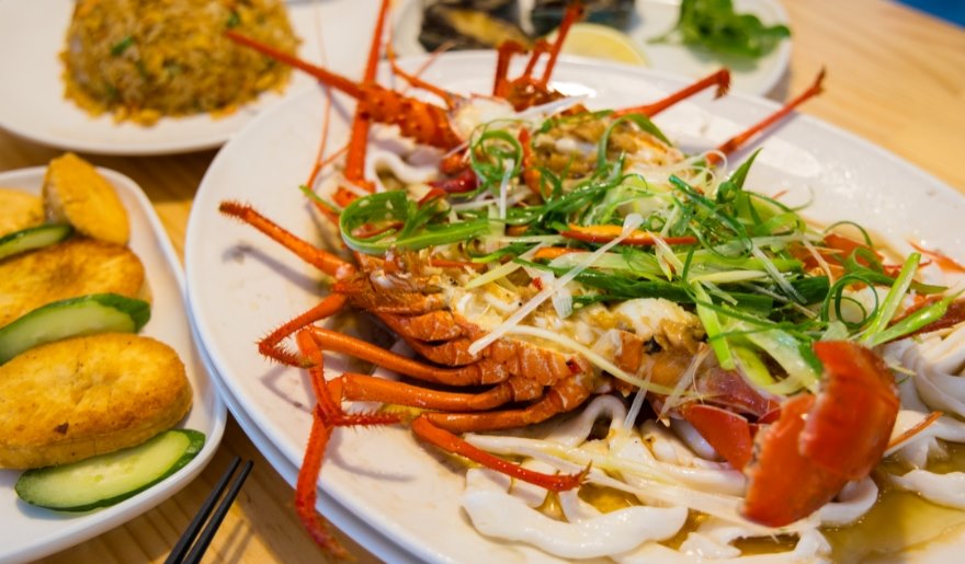 A plate of lobster and assorted dishes on a table at Sea Captain’s House, a Myrtle Beach restaurant for large groups.