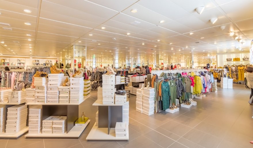Interior of a spacious store showcasing a wide selection of clothing and accessories at Myrtle Beach's Coastal Grand Mall.
