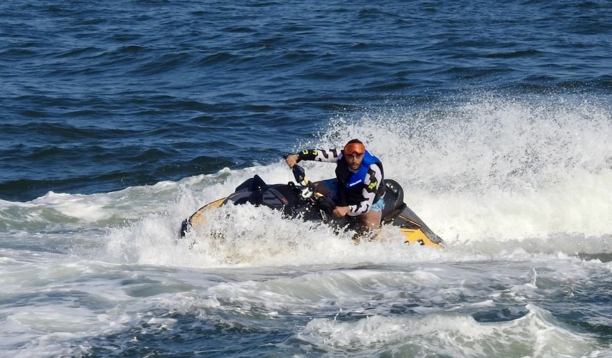 A man enjoys riding a jet ski on the ocean, showcasing thrilling beach and water activities at Myrtle Beach.