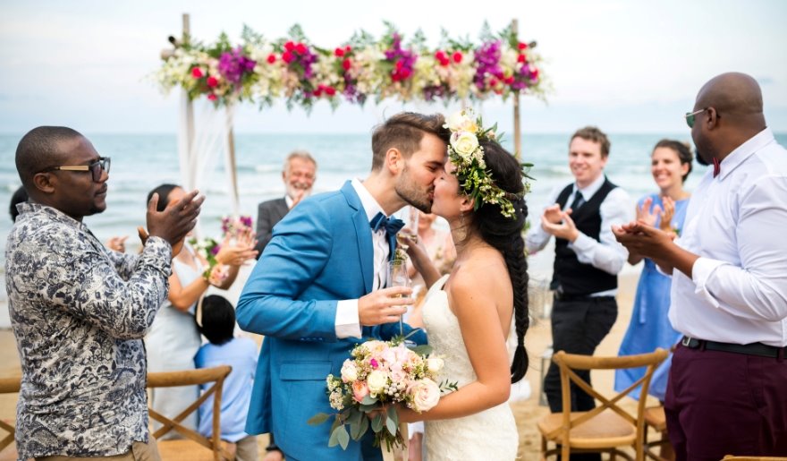 A bride and groom share a kiss on the beach during their wedding ceremony at Myrtle Beach, hosted by Simple Wedding Day, LLC.