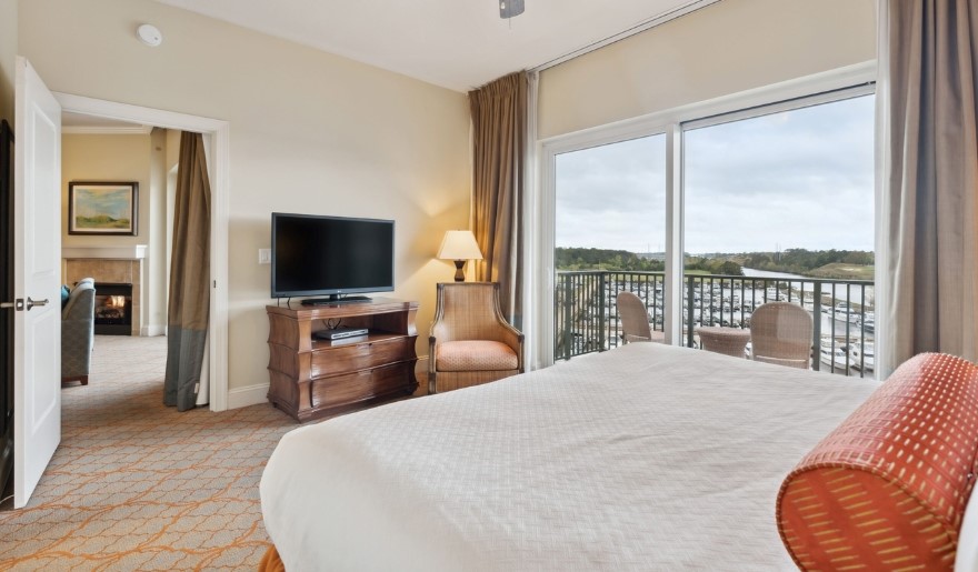 A spacious bedroom featuring a large bed and a television, designed for guest accommodations at Marina Inn at Grande Dunes.