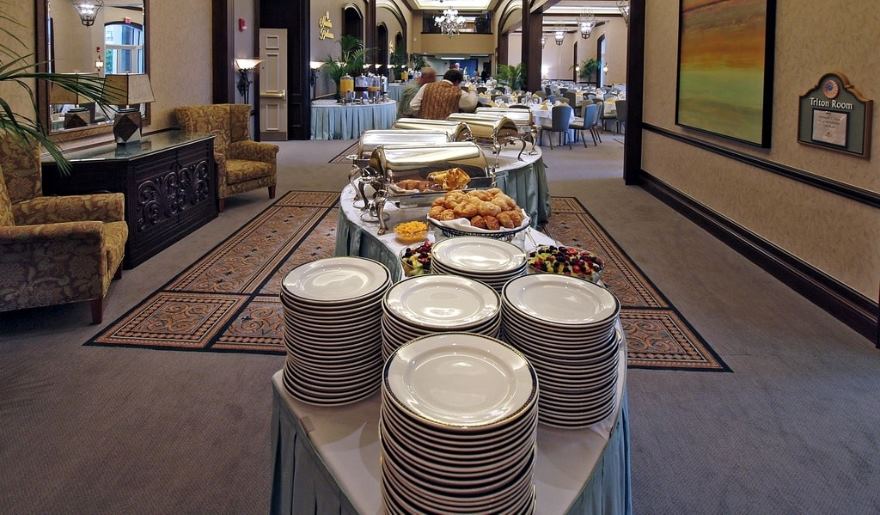 A buffet table filled with various dishes and plates, set up for an event in Marina Inn at Myrtle Beach.