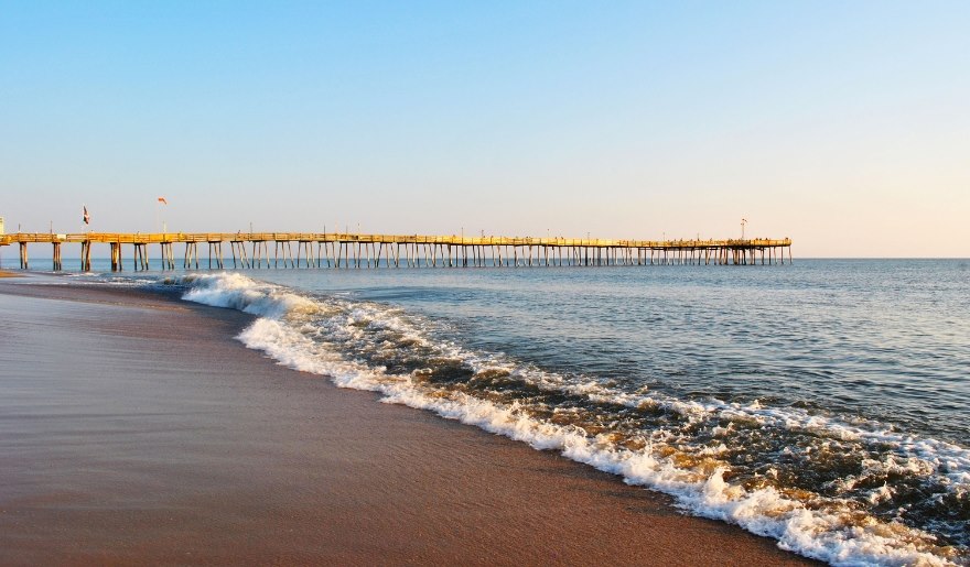 A scenic pier at Myrtle Beach with waves crashing onto the sandy shore, perfect for couples visiting Pawleys Island.